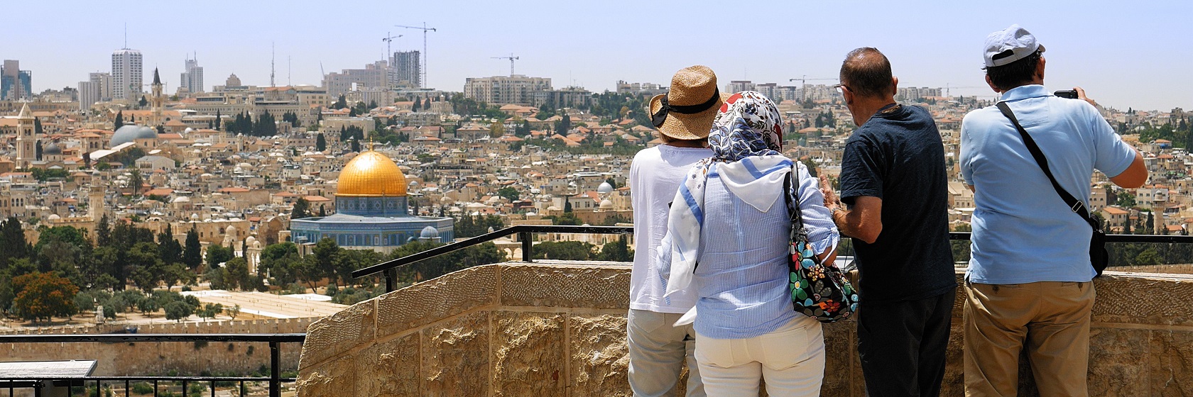 Fyra personer står på Olivberget och blickar ner över Tempelberget och gamla Jerusalem.