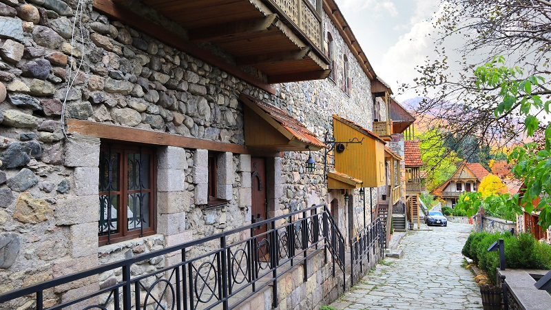 Gatubild fr�n Dilijan, med bostadshus i gr� sten.