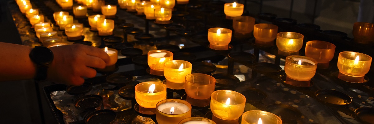 En mängd värmeljus i gula och orange ljusstakar lyser i Taizé.