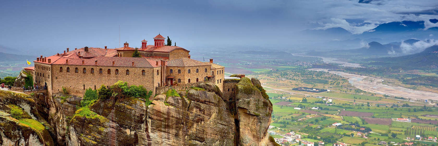 Ett kloster på toppen av en bergsformation med lodräta klippväggar vid Meteora.