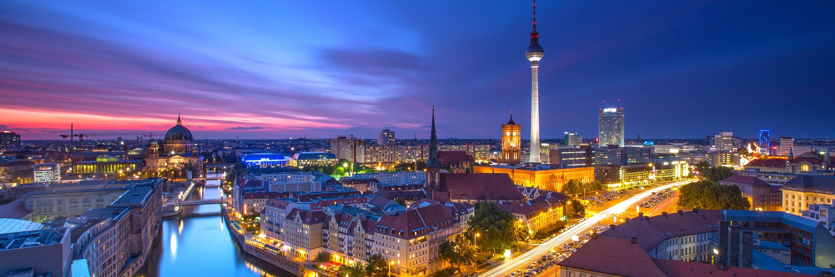 Berlin i skymningen, floden Spree lyses fortfarande upp av blå himmel och lamporna har börjat tändas.